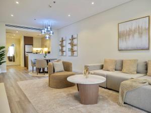 a living room with a couch and a table at Ambient 1BR Apartment On The Beach at 5 Star Resort in Dubai