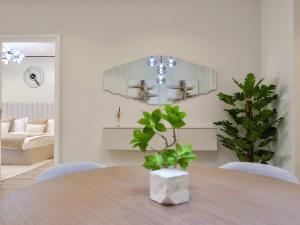 a dining room with a table and a chandelier at Ambient 1BR Apartment On The Beach at 5 Star Resort in Dubai