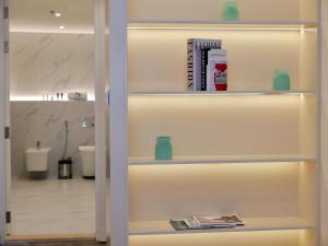 a book shelf with books and magazines on it in a bathroom at Ambient 1BR Apartment On The Beach at 5 Star Resort in Dubai