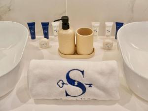 a towel with the letter s on it next to a sink at Ambient 1BR Apartment On The Beach at 5 Star Resort in Dubai