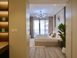 a bedroom with a large bed and a chandelier at Ambient 1BR Apartment On The Beach at 5 Star Resort in Dubai