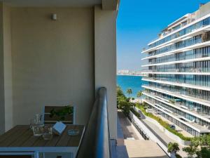 a balcony with a table and a view of a building at Ambient 1BR Apartment On The Beach at 5 Star Resort in Dubai