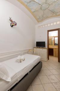 a bedroom with a bed and a tv on a ceiling at Domus 15 - Guest House in Rome