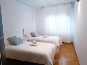 a room with two beds with towels on them at Apartamento San Pelayo, LA PICUDA in San Vicente de la Sonsierra