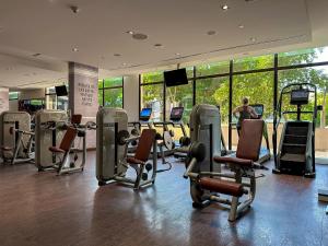 - une salle de sport avec des tapis de course et des chaises dans un bâtiment dans l'établissement Relaxing 1 bedroom apartment at 5 Star Resort, à Dubaï