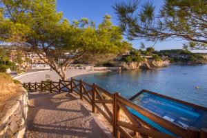 a swimming pool on a fence next to a body of water at Martí in Calpe