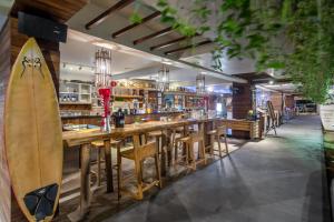 a bar with a surfboard on the wall at Bliss Surfer Hotel Legian in Legian