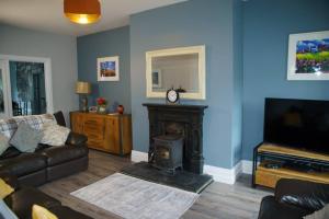 Una sala de estar con un sofá y una chimenea. en The Dingle Pass Escape, en Dingle