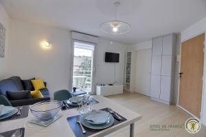 una sala de estar con una mesa y un sofá en Vue sur la station, en Erquy