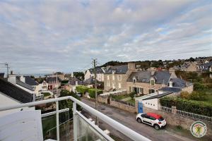 Un balcón con un coche aparcado en una ciudad. en Vue sur la station, en Erquy