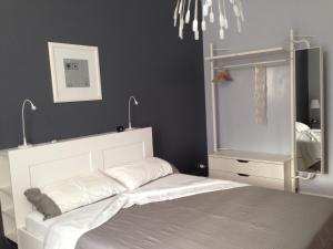 a bedroom with a white bed and a mirror at Casa Luthi in Siracusa
