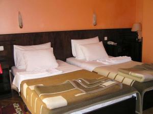 due letti uno accanto all'altro in una stanza di Hotel Royal a Kraljevo