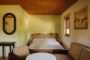 a bedroom with a bed and two chairs at Pension und Gastwirtschaft Mareile am Rennsteig in Rodacherbrunn