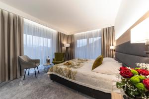 a bedroom with a bed and a desk with a chair at Hotel Solar in Szczawnica +26 photos