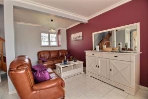 een woonkamer met een bank en een spiegel bij Le logis in Plouguenast +18 foto's