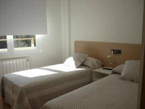 pokój hotelowy z dwoma łóżkami i oknem w obiekcie Pensión-Albergue Puente Ribeira w mieście Sarria