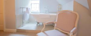a white bathroom with a tub and a sink at Little Massingham Manor in Little Massingham +51 photos