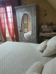 a bedroom with a bed with a mirror at Les Feuillantines Perigord Noir in Saint-Cyprien