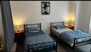 two twin beds in a room with two lamps at la chambre de Jade in Hirson