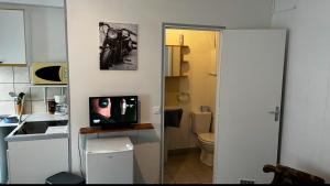 a bathroom with a toilet and a television on a counter at la chambre de Jade in Hirson