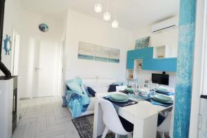 een witte eetkamer met een witte tafel en stoelen bij Galactic Sea in Comacchio +81 foto's