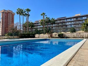 basen przed budynkiem z palmami w obiekcie Relax y Confort, Apartamento Reformado con Piscina w mieście Benidorm