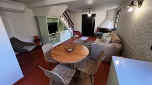 a living room with a table and chairs and a couch at Casa dos Lamaceiros in São Vicente