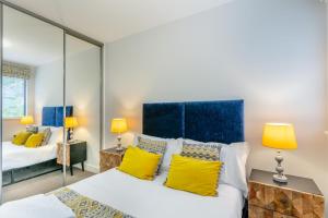 a bedroom with two beds and yellow pillows at 2 Middlecombe - Luxury Apartment at Byron Woolacombe, only 4 minute walk to Woolacombe Beach! in Woolacombe +36 photos