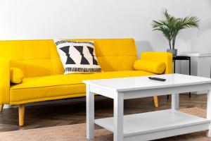 a yellow couch and a white coffee table in a living room at Stylish 2 Bedroom Apartment - Free WiFi - Netflix - Wolverhampton Centre - 2TO in Wolverhampton