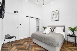 a bedroom with white walls and a bed and wooden floors at Stylish 2 Bedroom Apartment - Free WiFi - Netflix - Wolverhampton Centre - 2TO in Wolverhampton +34 photos