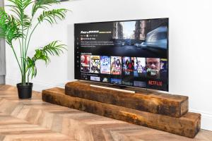 a flat screen tv sitting on top of a wooden table at Stylish 2 Bedroom Apartment - Free WiFi - Netflix - Wolverhampton Centre - 2TO in Wolverhampton