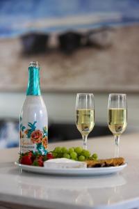 una mesa con dos copas de vino y un plato de comida en Knysna - Cycad Cottage, en Knysna
