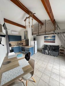 a kitchen and living room with a table and chairs at La maison de la mer in Fleury