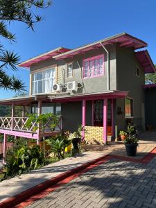 a house with pink trim and a driveway at Pousada Recanto Barão de Biguaçu in Biguaçu