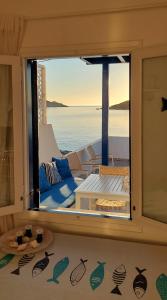 a large window with a view of the ocean at Harmonia Beach House in Kimolos +34 photos