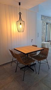 a dining room table with chairs and a light fixture at Margo Beach Hotel in Gythio