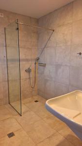 a bathroom with a shower and a tub and a sink at Margo Beach Hotel in Gythio