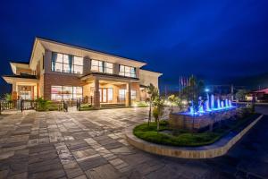 un edificio con una fontana di fronte ad esso di notte di Regenta Resort & Spa By Riverside, Chitwan a Chitwan