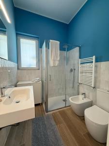 Un baño con lavabo, inodoro y ducha. en Villa Acquamarina, en Villaggio San Leonardo