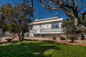 a white building with a yard in front of it at Villa Sandoval in Palermo