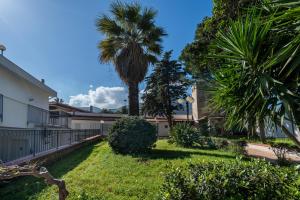 a yard with a palm tree and a building at Villa Sandoval in Palermo