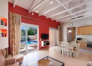 una cucina e un soggiorno con pareti rosse e tavolo di Maria by Vintage Travel a Città di Lefkada