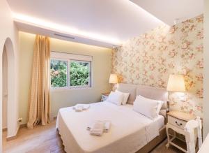 una camera da letto con un letto bianco e una finestra di Maria by Vintage Travel a Città di Lefkada Altre 27 foto