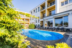 an image of a swimming pool in front of a building at Lázeňský a Wellness hotel NIVAMARE in Luhačovice +41 photos