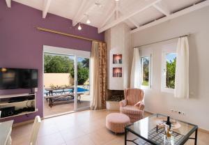 un soggiorno con pareti viola e tavolo in vetro di Leda by Vintage Travel a Città di Lefkada