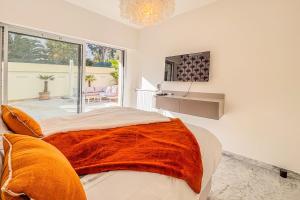 Un dormitorio con una cama con una manta naranja. en 2P Apartment Just Steps from Antibes Beaches, en Antibes