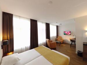 een hotelkamer met een bed en een bureau. bij Hotel Residence Le Coin in Amsterdam