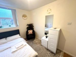 a bedroom with a bed and a dresser and a mirror at Mos' Place in Manchester