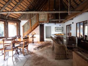 a living room with a table and chairs at Rhino River Lodge in Manyoni Private Game Reserve