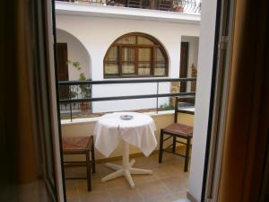 una mesa y sillas en un balcón con ventana en Pansion Chrisa en Skíathos
